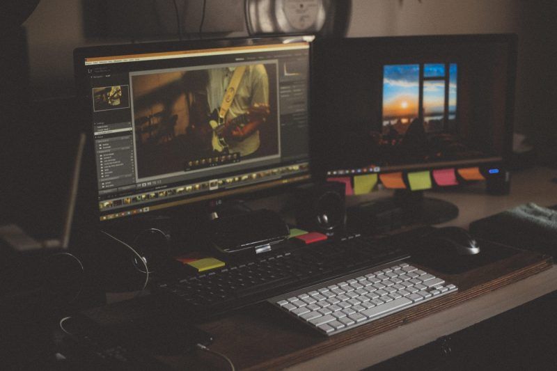 computador com duas telas editando uma fotografia de um músico