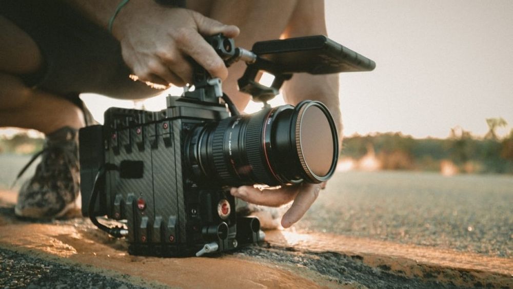 mãos masculinas seguram uma câmera profissional durante uma filmagem