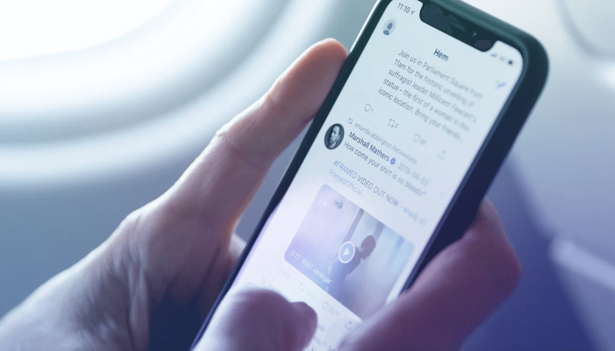 detalhe de mão segurando um celular com a tela aberta na plataforma Twitter