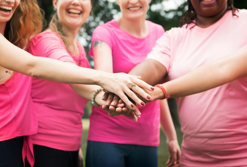 grupo de mulheres diversas em um evento para conscientização e ação de prevenção ao câncer de mama